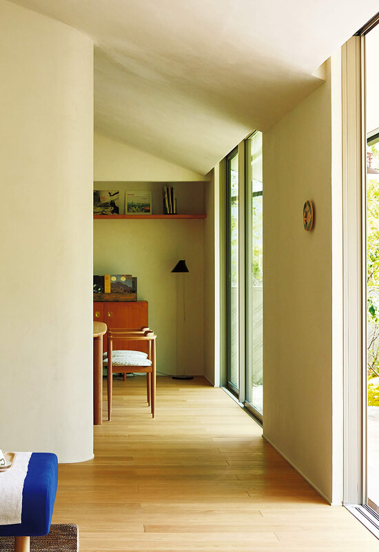 緑を望む明るい廊下から続く書斎スペース。ヴィンテージ家具が映える落ち着いた空間